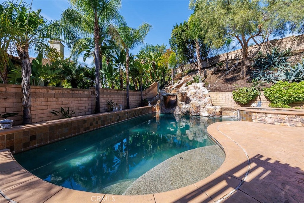 View of the pool with Baja Shelf in the foreground. Rock slide with steps to the top are at the far end. - 18001 Catalina Court, Yorba Linda CA 92886 - photo 1