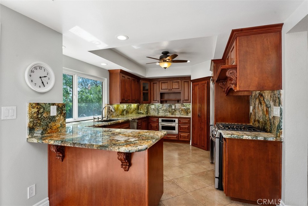 Rich wood cabinetry and beautiful granite along with stainless steel appliances round out this great kitchen. - 21674 Calle Alcazar, Yorba Linda CA 92887 - photo 8