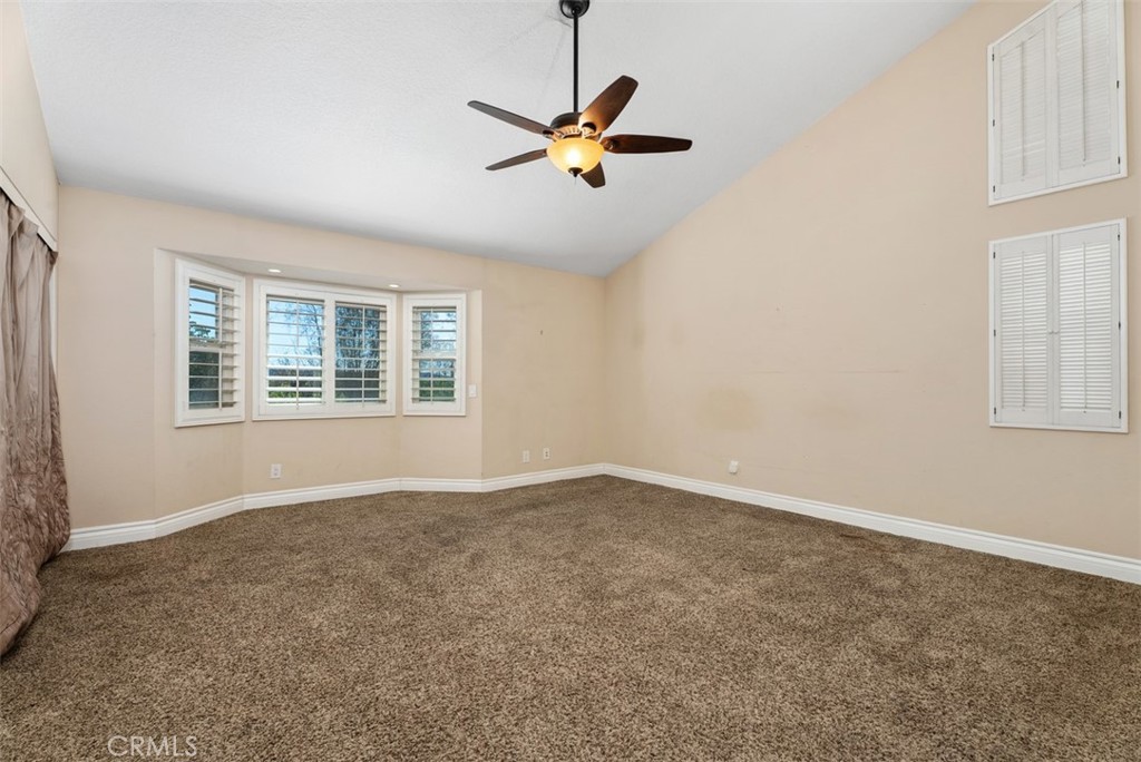 Spacious Primary Suite with vaulted ceiling, lighted ceiling fan, carpeted flooring and shutters on the windows. - 21674 Calle Alcazar, Yorba Linda CA 92887 - photo 22