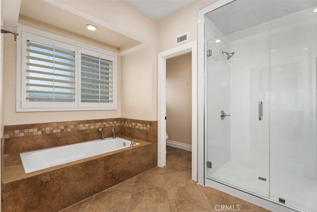 Relaxing soaking tub, walk in shower and private toilet in the primary suite. - 21674 Calle Alcazar, Yorba Linda CA 92887 - photo 25