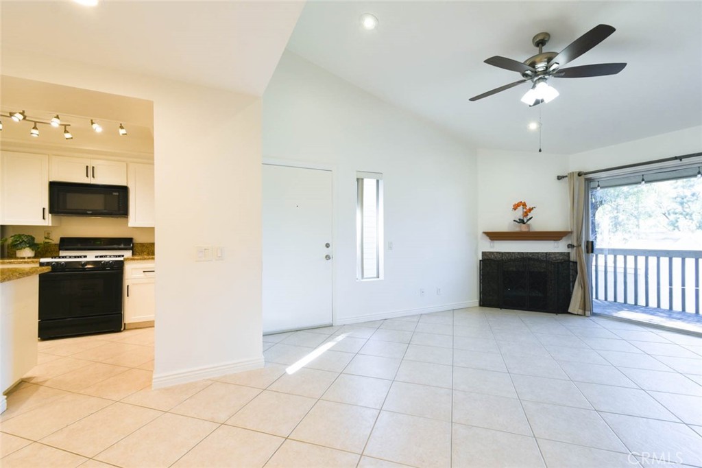 The living room with high ceiling on the right side and the kitchen and the dining room on the left side. The front door - 23472 Cambridge Road 297, Yorba Linda CA 92887 - photo 3
