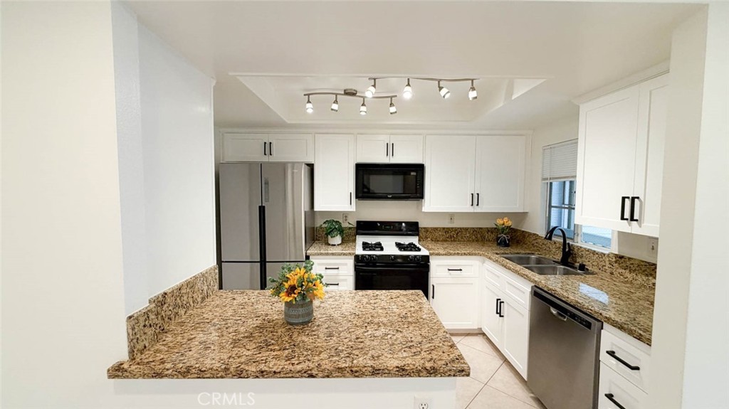 The kitchen was fully remodeled some years ago with granite countertop, gas stove, built-in microwave, stainless steel d - 23472 Cambridge Road 297, Yorba Linda CA 92887 - photo 11