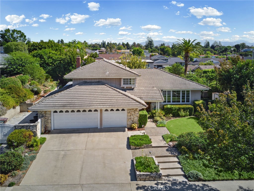 View os the home featuring mature trees, & lush landscaping. There its a a 3-car garage with extra driveway parking, in - 5062 W Knoll Drive, Yorba Linda CA 92886 - photo 3