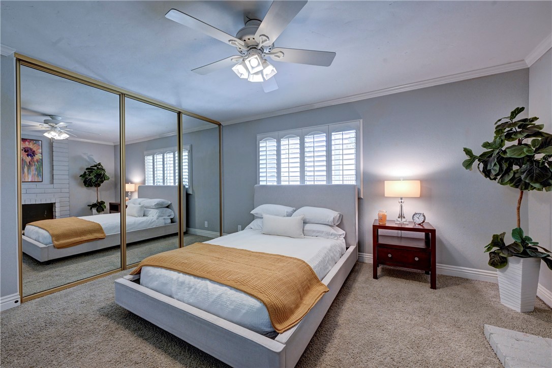 Downstairs Bedroom #3 has mirrored wardrobe doors, a lighted ceiling fan and shutters on the window. - 5561 Orchard, Yorba Linda CA 92886 - photo 32